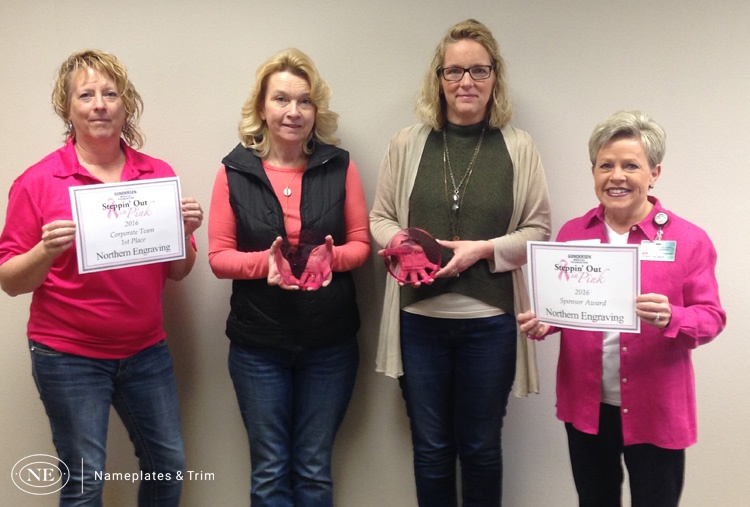 Northern Engraving accepts award for corporate team from Steppin' Out in Pink